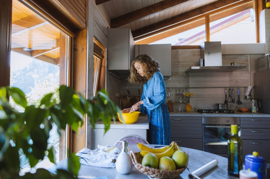 woman cooking in cottage kitchen